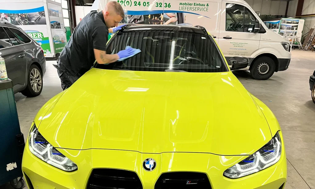 Autoglas-Techniker reinigt eine Windschutzscheibe nach der Reparatur